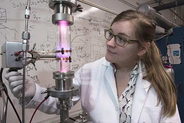 University of Minnesota researcher Samantha Ehrenberg uses a plasma reactor to create silicon nanoparticles that are the key ingredient in the solar concentrators. Photo credit: University of Minnesota