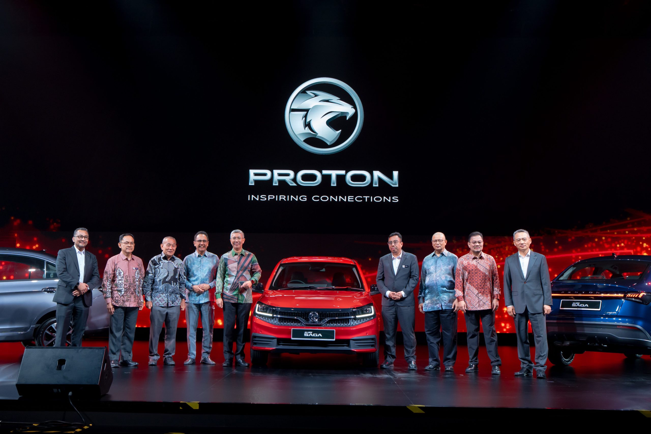 Group of PROTON, DRB-HICOM and MITI leaders standing on stage with the All-New Proton Saga during its official launch event.