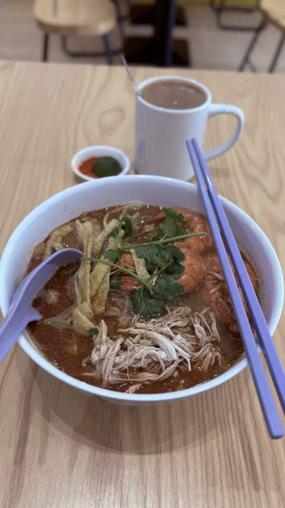 Bowl of Sarawak Laksa from Lin Yu Mei at Joo Chiat, served with prawns and thick, aromatic broth.