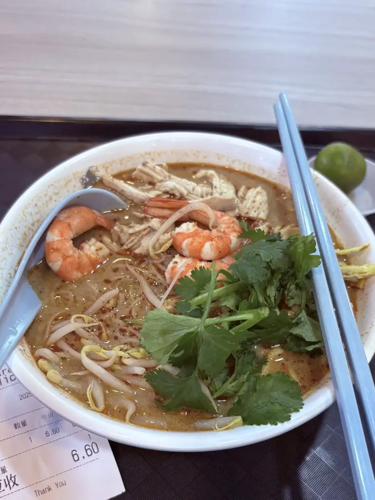 Sarawak Delicacy’s laksa bowl, featuring prawns, chicken strips, and fragrant broth.